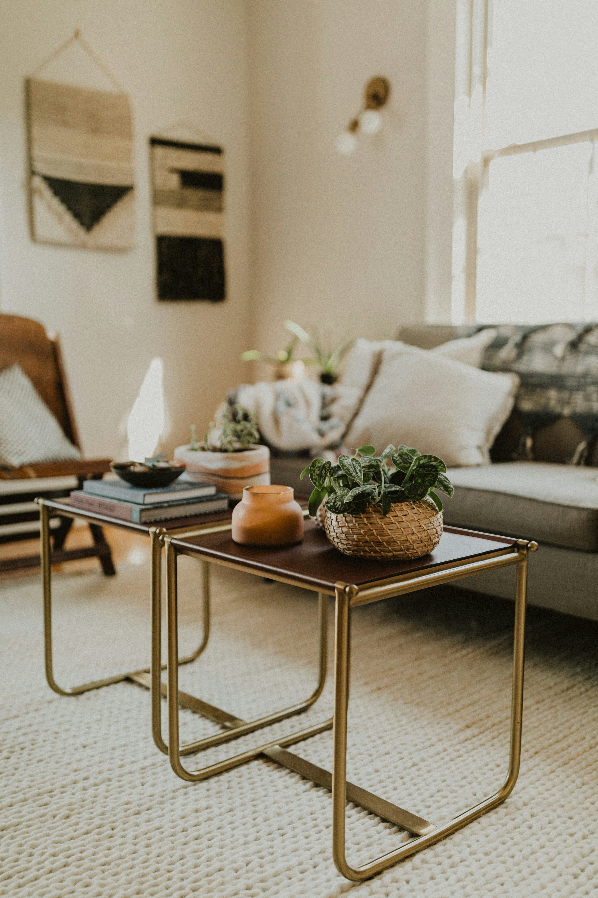 A hip, cozy living room with comfy couch and coffee table, stacked with beautiful coffee table books.