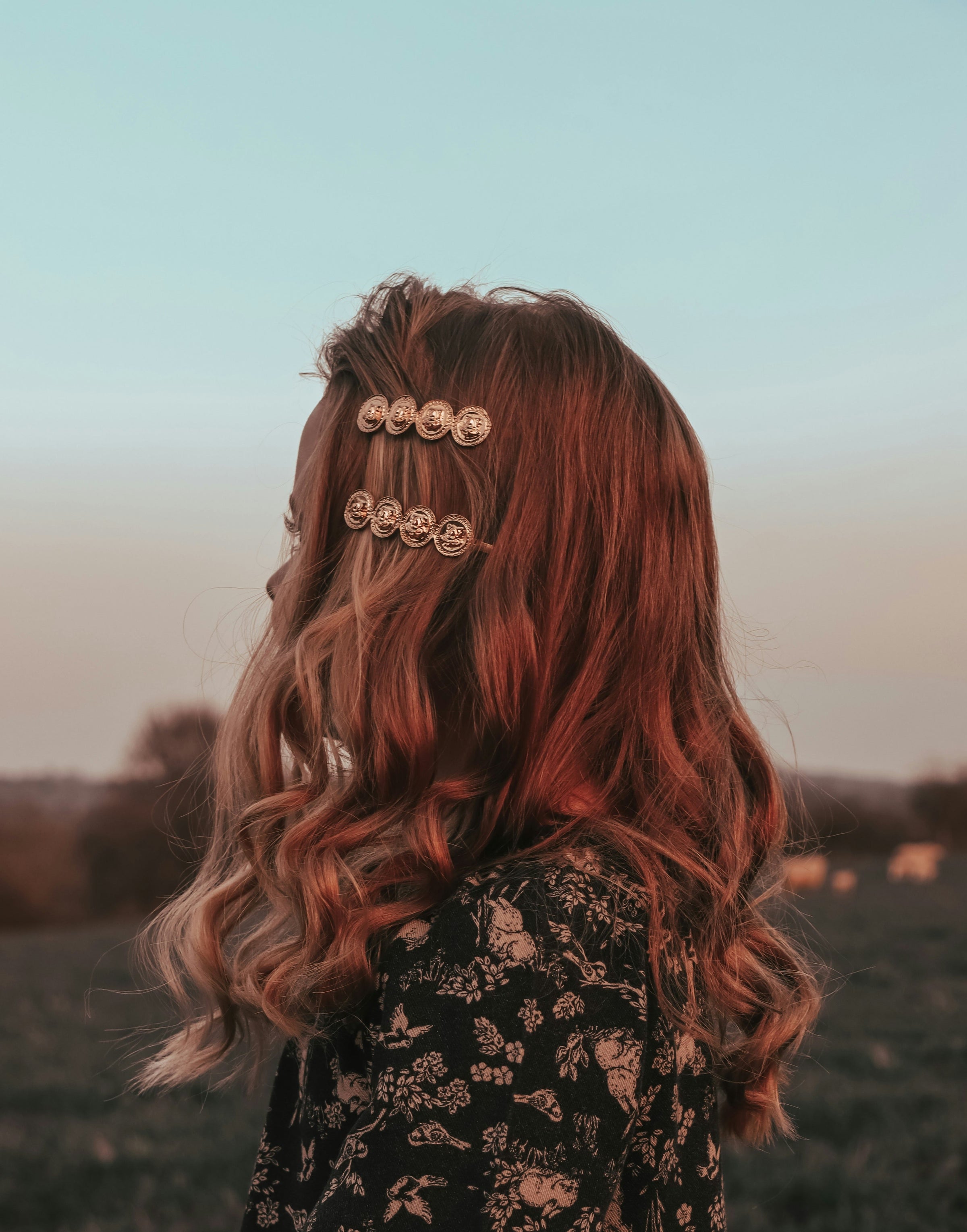 Beautiful wavy blonde hair with two brass hair pins tucked in.